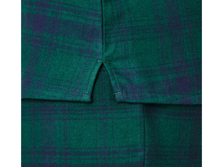 Gros plan d'une chemise à carreaux verts avec fente latérale.