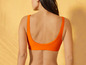 Une femme portant un haut de bikini orange.