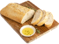 Pain et tranches coupées sur planche en bois avec huile d'olive et herbes.