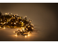 Guirlande de Noël avec des lumières LED blanc chaud et des aiguilles vertes sur fond clair.