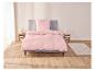 Une parure de lit rose sur un lit dans une chambre.