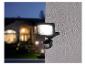 Lumière LED extérieure noire avec capteur de mouvement montée sur un mur.