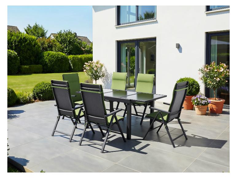 Ensemble de salle à manger de patio avec table noire et six chaises avec coussins verts sur une terrasse carrelée.