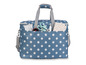 Un sac bleu à pois blancs avec des poignées, rempli d'accessoires de couture.