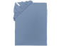 Drap-housse bleu avec élastique dans le coin et une étiquette blanche.