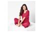 Femme en pyjama rouge avec de la dentelle, assise sur un canapé blanc.