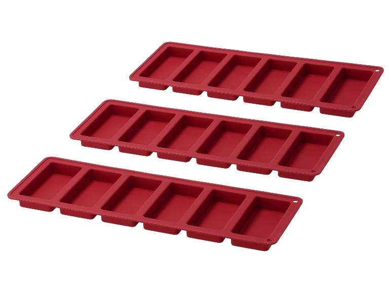 Trois moules en silicone rouges pour faire des barres de chocolat ou des savons.