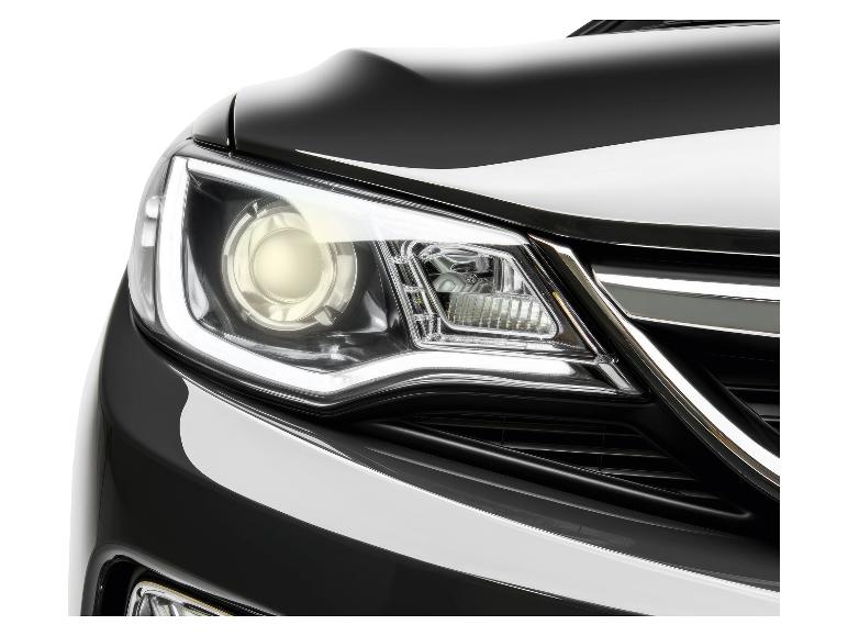 Avant d'une voiture noire avec les phares allumés.