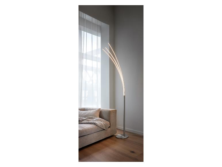 Un lampadaire moderne avec des bras courbés dans un salon clair.