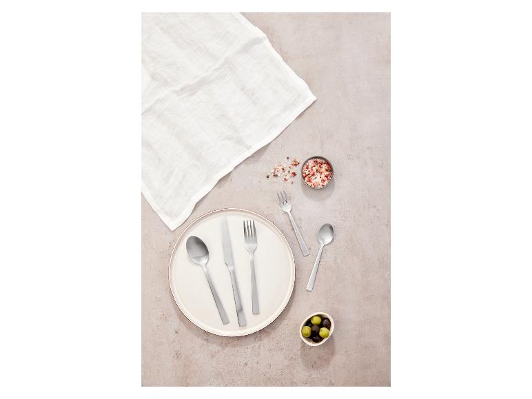 Un couvert, une assiette et un bol d'olives