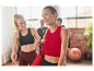 Deux femmes heureuses en vêtements de sport portent des tapis de yoga après un cours de fitness.