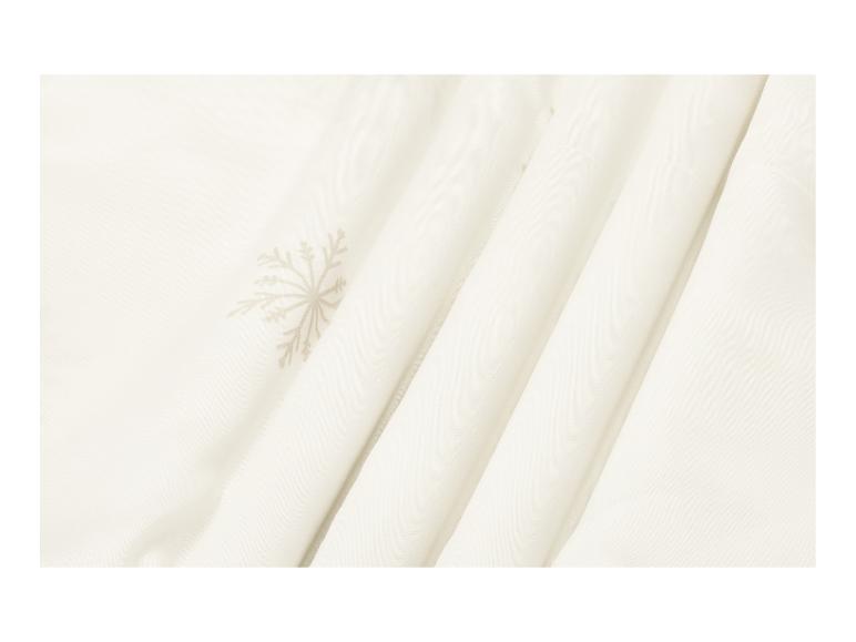 Tissu couleur crème avec un motif de flocon de neige subtil et des plis doux.