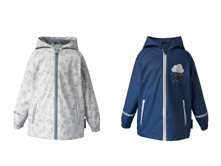Deux vestes de pluie pour enfants : une blanche à motifs de voitures et une bleue avec un nuage et 'HAPPY DAY'.
