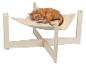 Chat roux dormant paisiblement dans un hamac en peluche beige avec un cadre en bois clair.