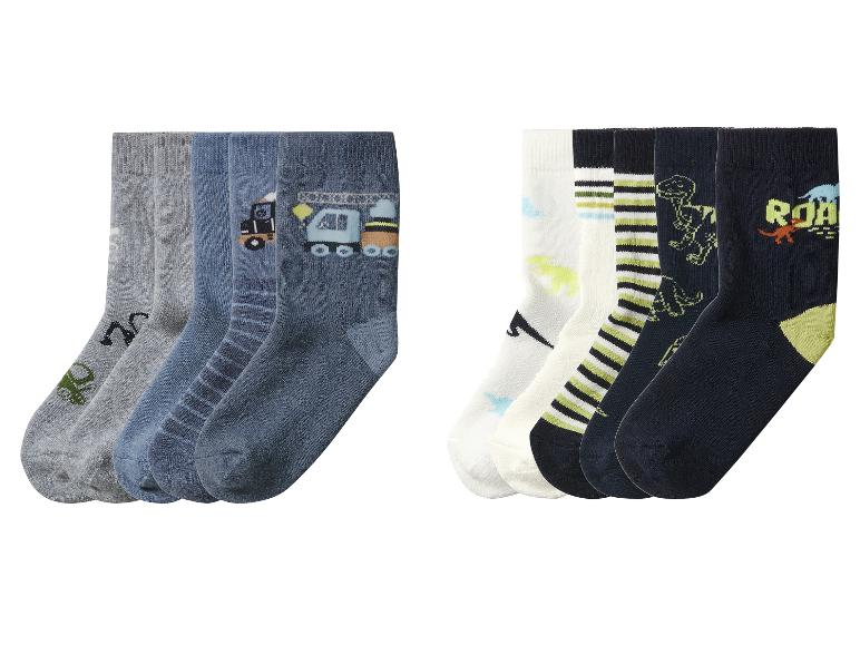 Deux ensembles de chaussettes pour enfants, un avec des véhicules et un avec des dinosaures.
