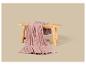 Plaid rose doux sur un banc en bois.