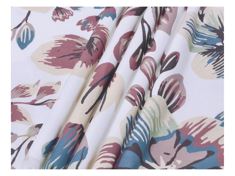 Tissu blanc avec un motif floral dans des tons de bleu, vert et marron.