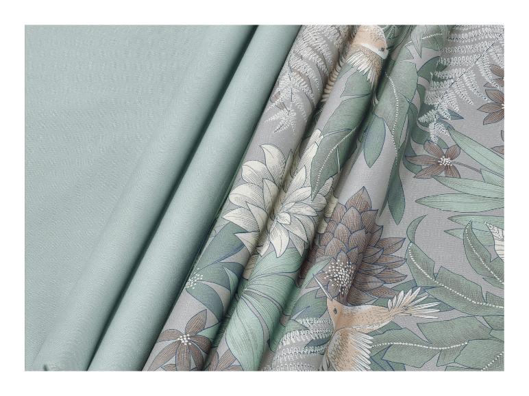 Rideaux en deux tons de vert, l'un uni et l'autre avec un motif floral et d'oiseaux.
