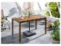 Une table de jardin en bois avec un parasol et une chaise