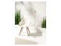 Chaise design blanche, lampadaire et plantes vertes dans un décor minimaliste.