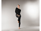 Femme posant dans un ensemble de sous-vêtements thermiques noirs moulants.