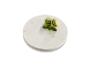 Deux macarons verts sur un dessous de plat en marbre.