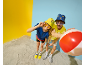 Deux personnes souriantes avec des chapeaux bob et des lunettes de soleil, jouant avec un ballon de plage.