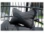 Gros plan d'un coussin noir avec le texte 'HOME DELUXE' dans un fauteuil suspendu.