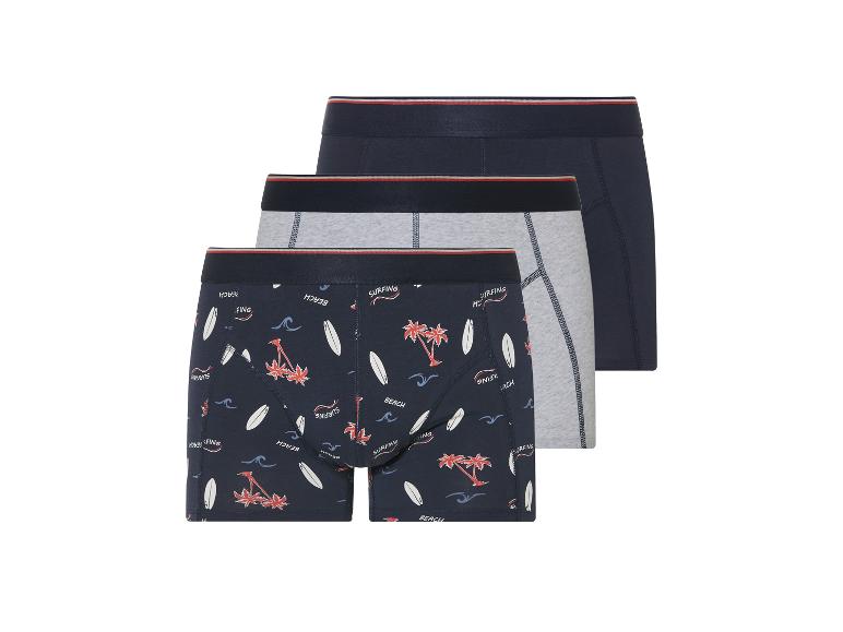 Trois boxers homme : un imprimé surf, un gris chiné et un bleu marine uni.