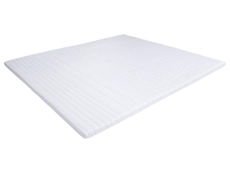 Protège-matelas ou surmatelas blanc posé sur un fond blanc.