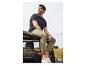 Un homme en polo et pantalon chino assis sur une Jeep.