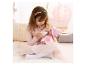 Fille nourrissant une poupée bébé au biberon, entourée de décor rose.