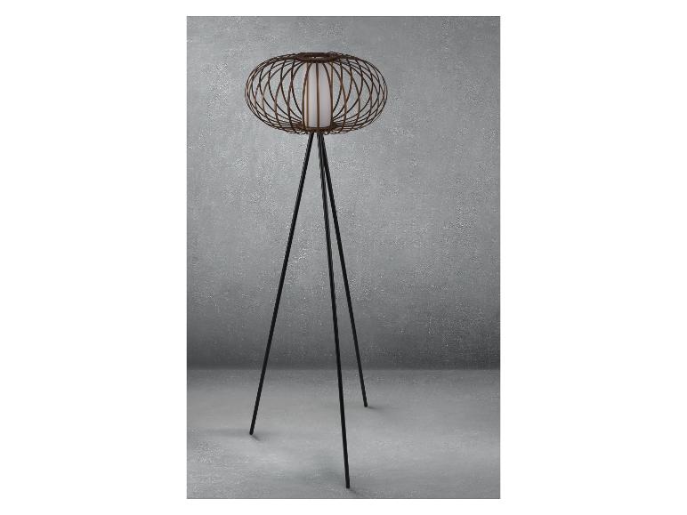 Un lampadaire noir avec un abat-jour rond en osier.