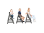 Trois enfants assis sur des chaises hautes en bois gris.