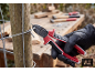 Pince coupante coupant un fil de fer sur une clôture en bois.