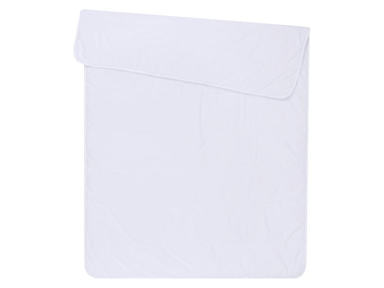 Couverture ou couette matelassée blanche, pliée dans le coin supérieur
