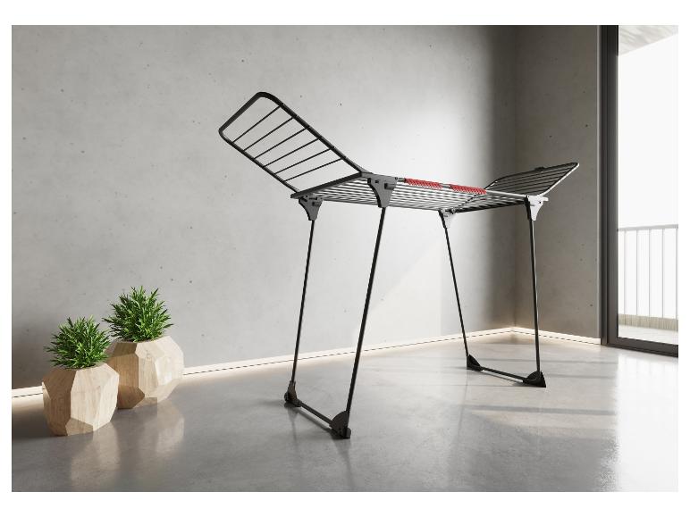 Séchoir à linge dans une pièce moderne avec plantes et balcon.