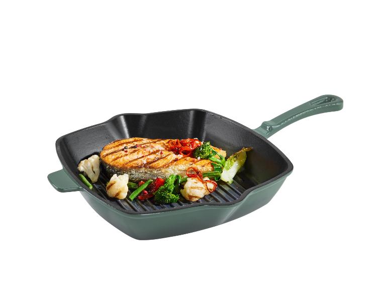 Une poêle verte avec du saumon et des légumes grillés.