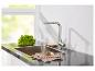 Un robinet de cuisine moderne avec douchette extractible, un évier et une serviette.