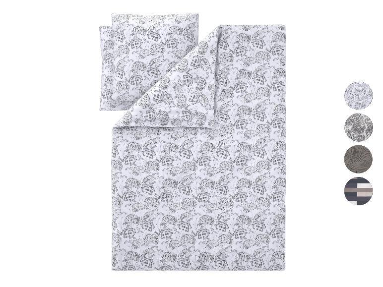 Parure de lit avec motif floral gris et blanc, avec oreiller assorti.