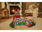 Enfant joue avec un train et un terrain de football dans un salon de Noël douillet.