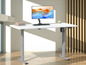 Un bureau blanc à hauteur réglable, avec un moniteur et un clavier.