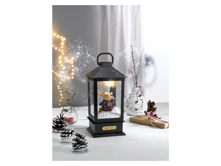 Une lanterne de Noël avec un renne à l'intérieur.