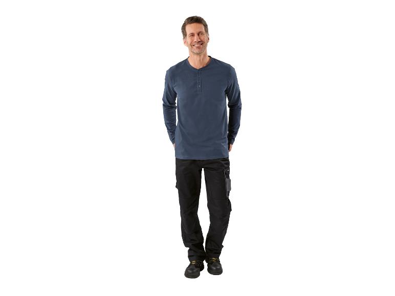 Homme en t-shirt bleu à manches longues et pantalon de travail noir