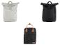 Trois sacs à dos: deux gris clair et noirs avec fermeture roll-top, un noir avec poignées marron.