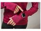Une femme porte un sweat-shirt rouge à manches longues avec une Apple Watch au poignet.