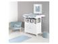 Chambre de bébé avec table à langer blanche, fauteuil bleu et tapis.
