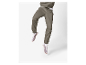 Pantalon de jogging kaki et baskets blanches.