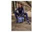 Une femme en tenue de sport violette assise avec des chaussures de sport CRIVIT et un sac.