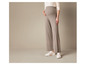 Un mannequin porte un pantalon en tricot beige clair avec des baskets blanches.